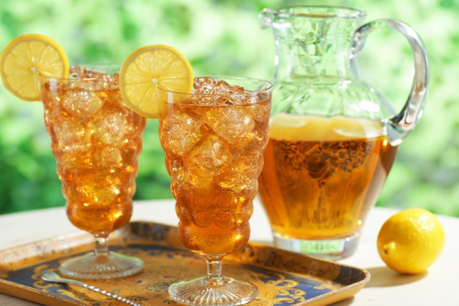 Two glasses of iced tea with pitcher.  Selective focus.